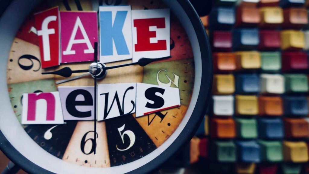 A clock face with the words “fake news” spelled out using cut-out magazine letters