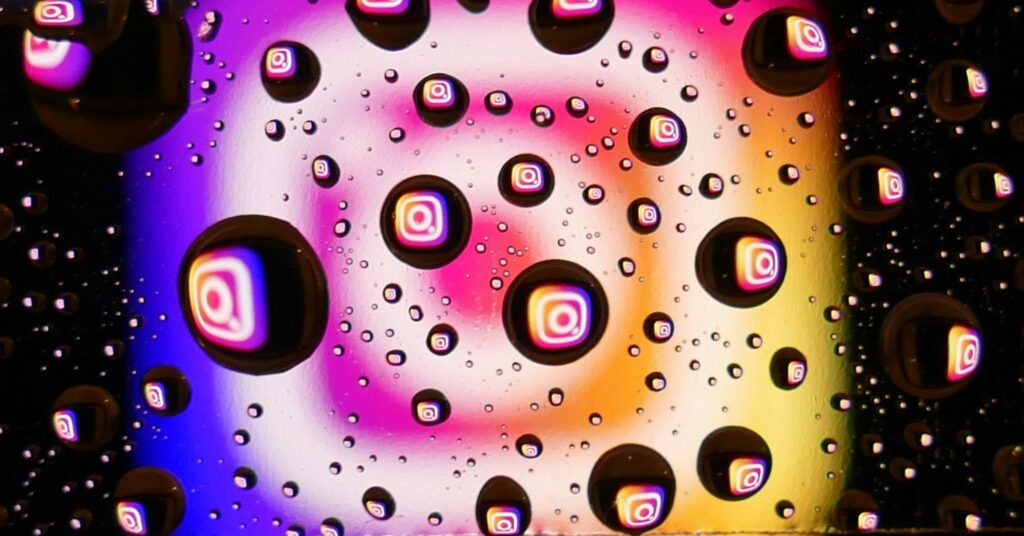 Abstract background with Instagram logo reflections inside water droplets on a colorful gradient surface, representing social media marketing, Instagram branding, digital engagement, and online content sharing.