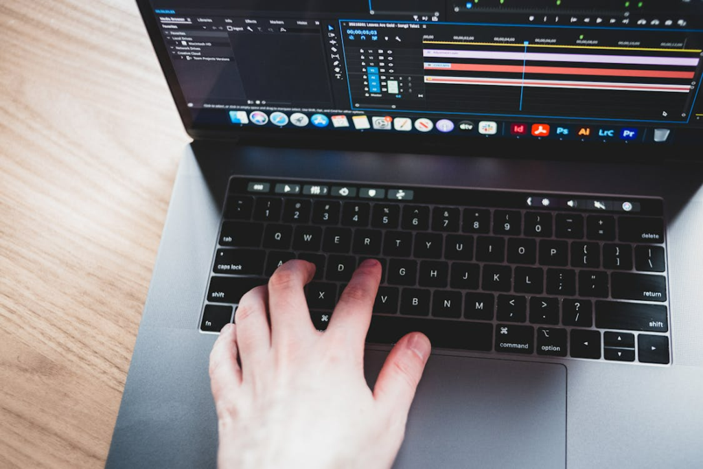 Man using music editing program on laptop.