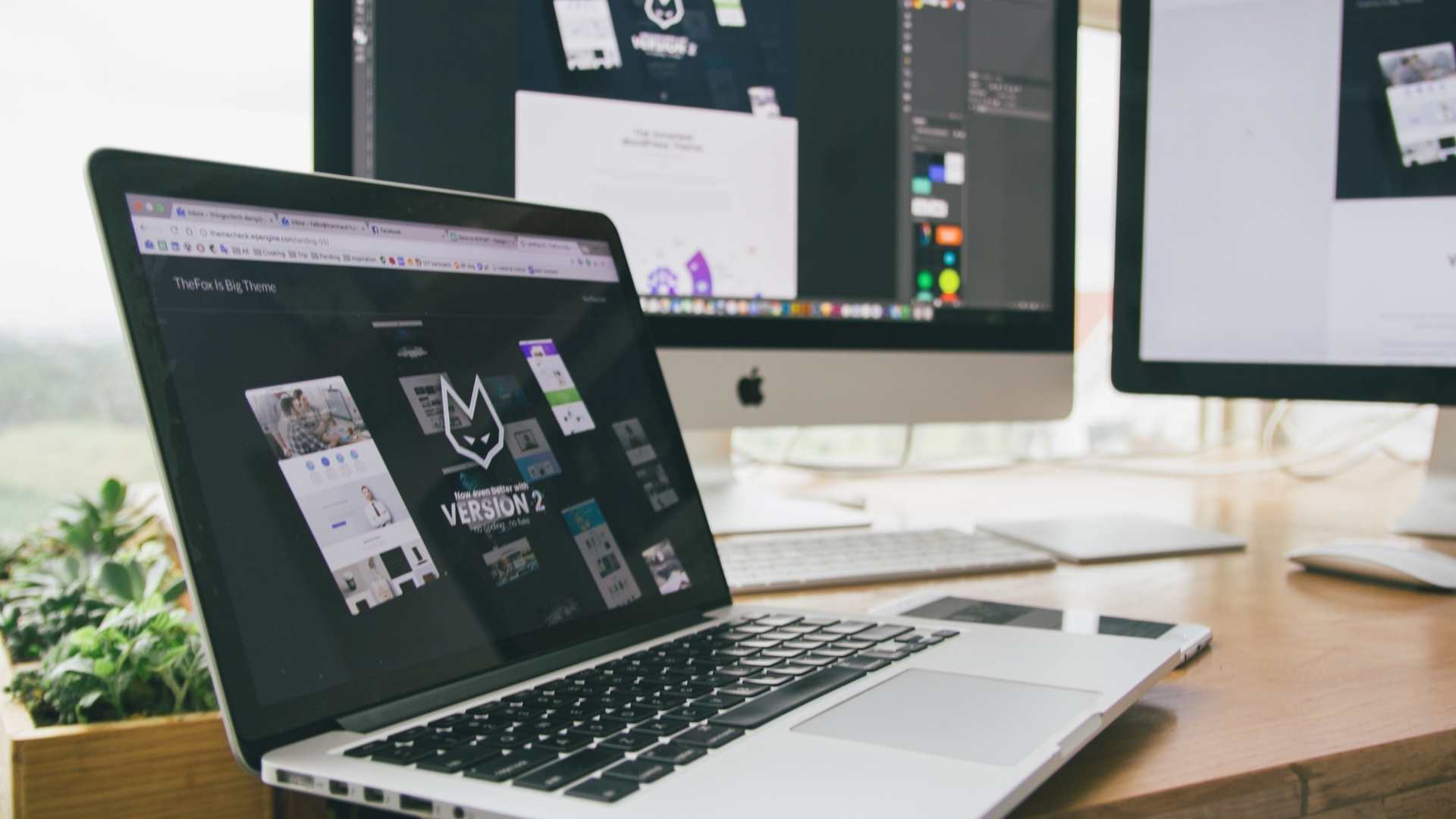 Web design workspace with multiple screens displaying website layouts and digital design tools