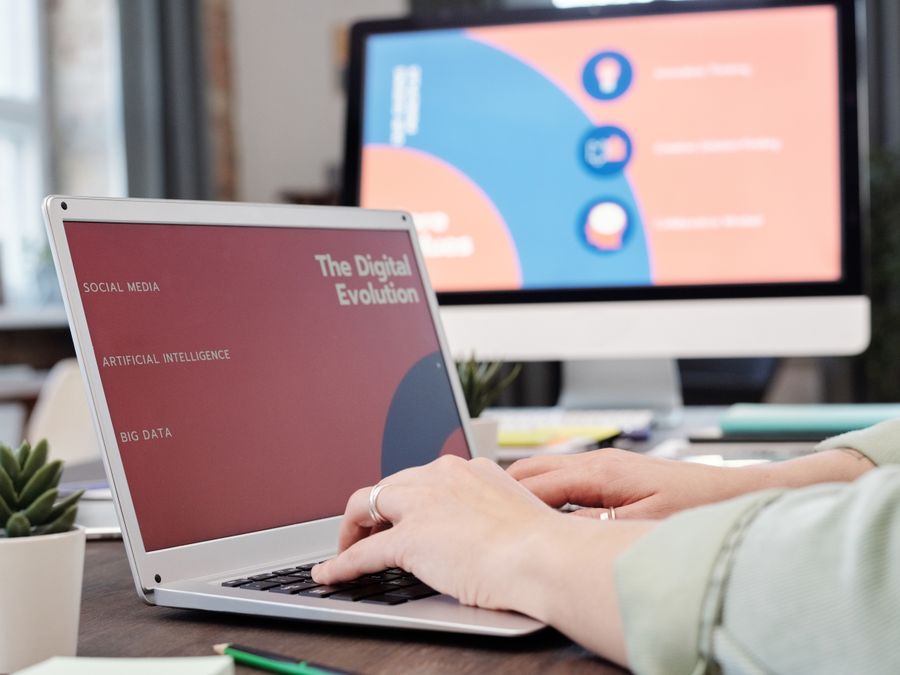 Laptop user typing with digital evolution concept on screen in a modern office environment.
