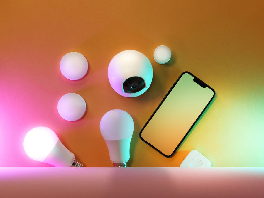 A collection of smart home devices including light bulbs and a smartphone, showcasing modern technology.