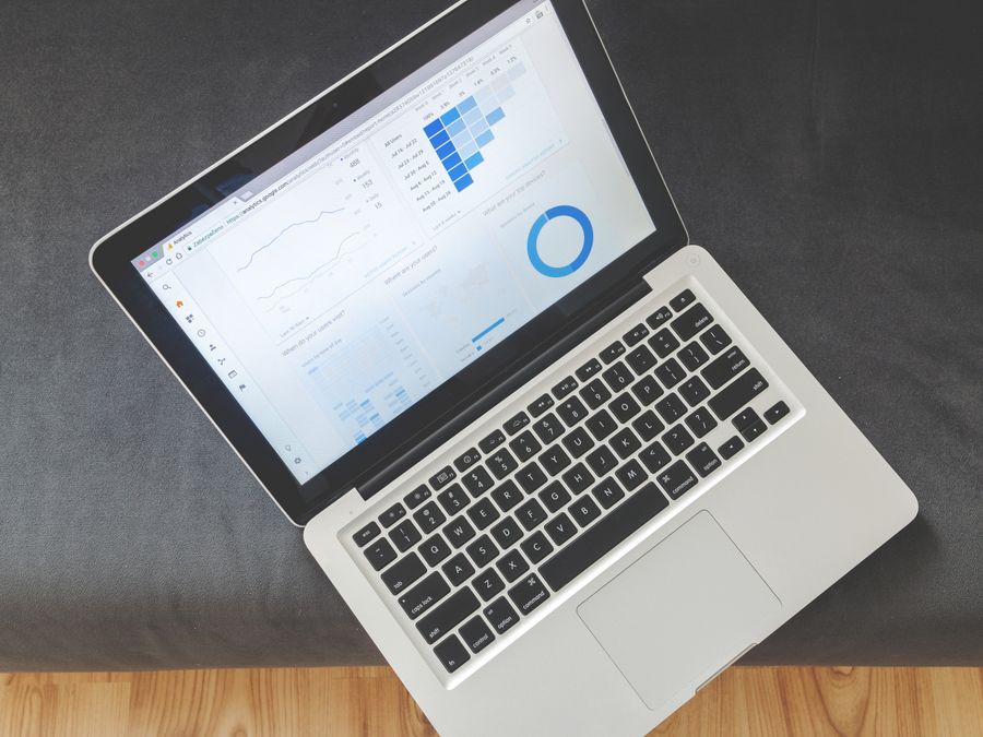 Overhead view of a laptop showing data visualizations and charts on its screen.
