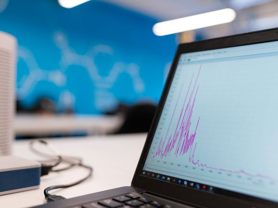 Laptop displaying data analytics graph in a modern office setting, symbolizing growth and technology.
