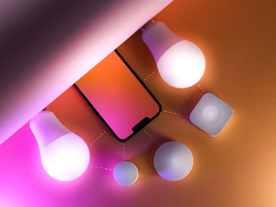 Creative arrangement of smart light bulbs and smartphone illustrating smart home technology.