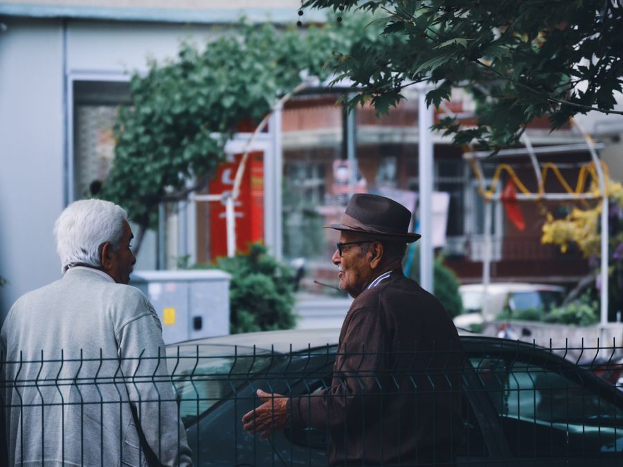 Two senior men are engaged in conversation in a town setting in Ereğli, Türkiye.