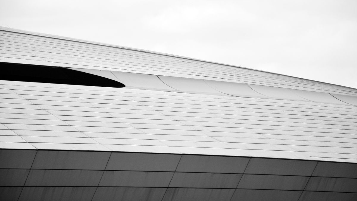 Black and white photo of a modern architectural facade showcasing sleek geometric lines and minimalistic design.