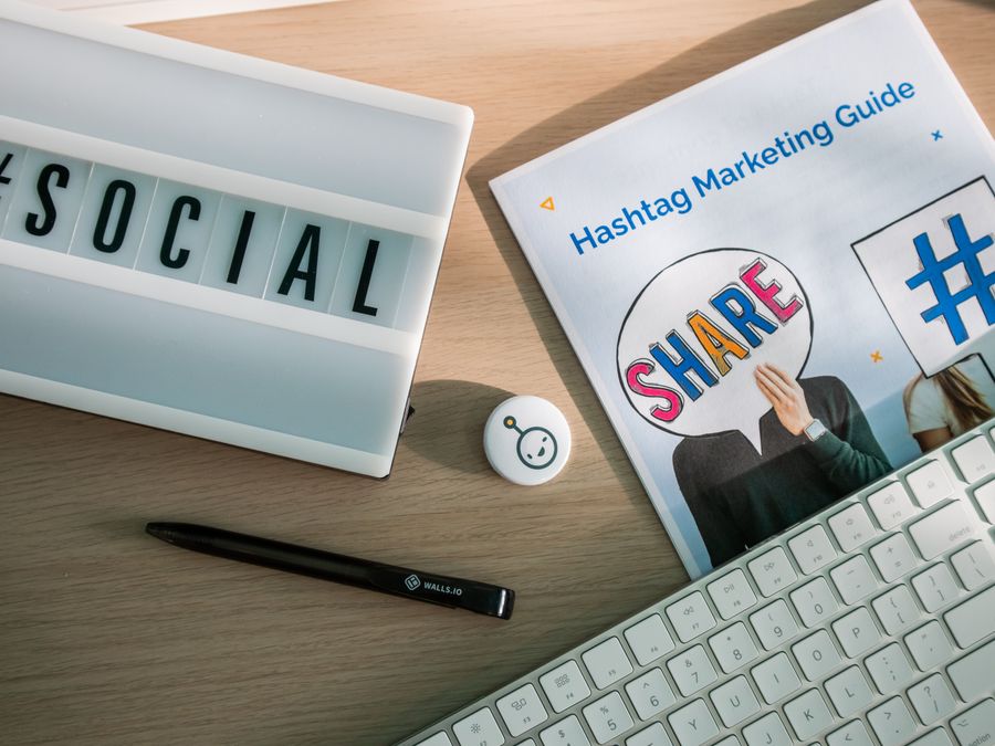 A desktop setup with social media marketing essentials including a keyboard, lightbox, and guide.