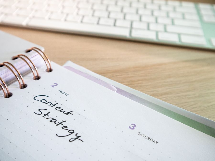 Content strategy written in planner with keyboard on wooden desk