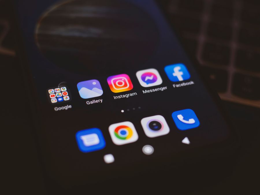 A smartphone displaying popular social media apps in a dimly lit environment, perfect for tech and communication themes.