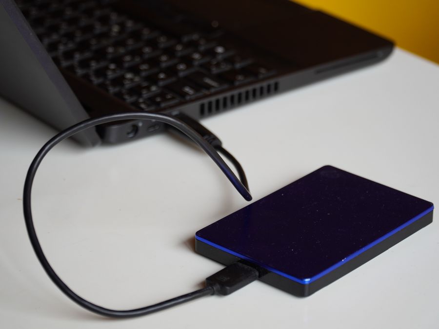 External hard drive connected to a laptop, showcasing portable storage solution.