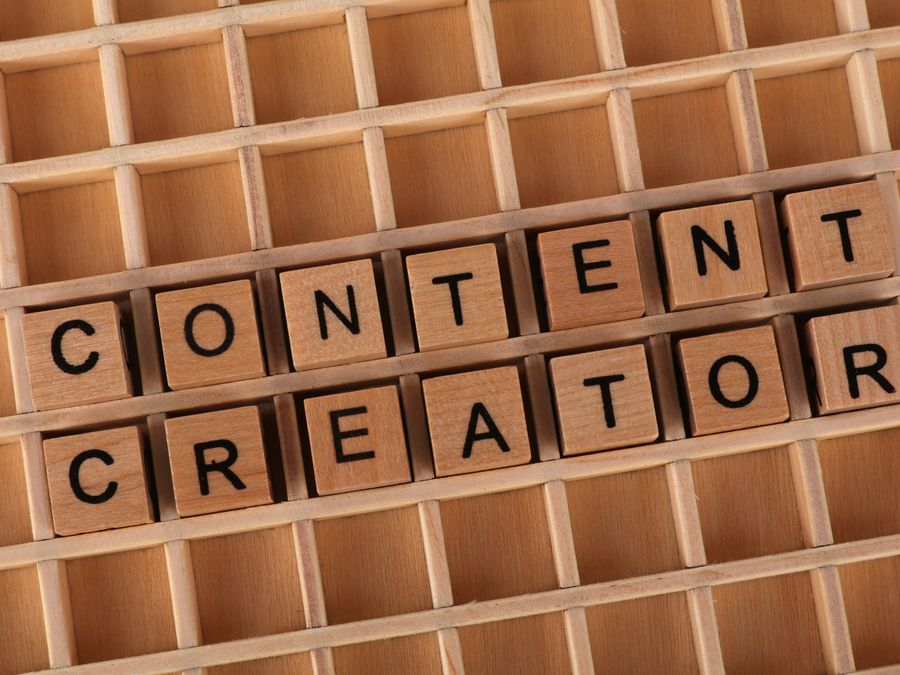 Wooden letter blocks arranged to spell 'Content Creator' symbolizing creativity and digital media.