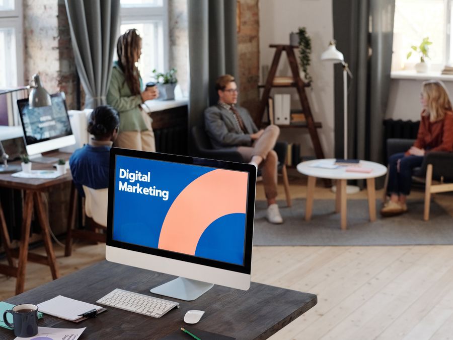 Collaborative team meeting in a modern office setting with digital marketing focus.