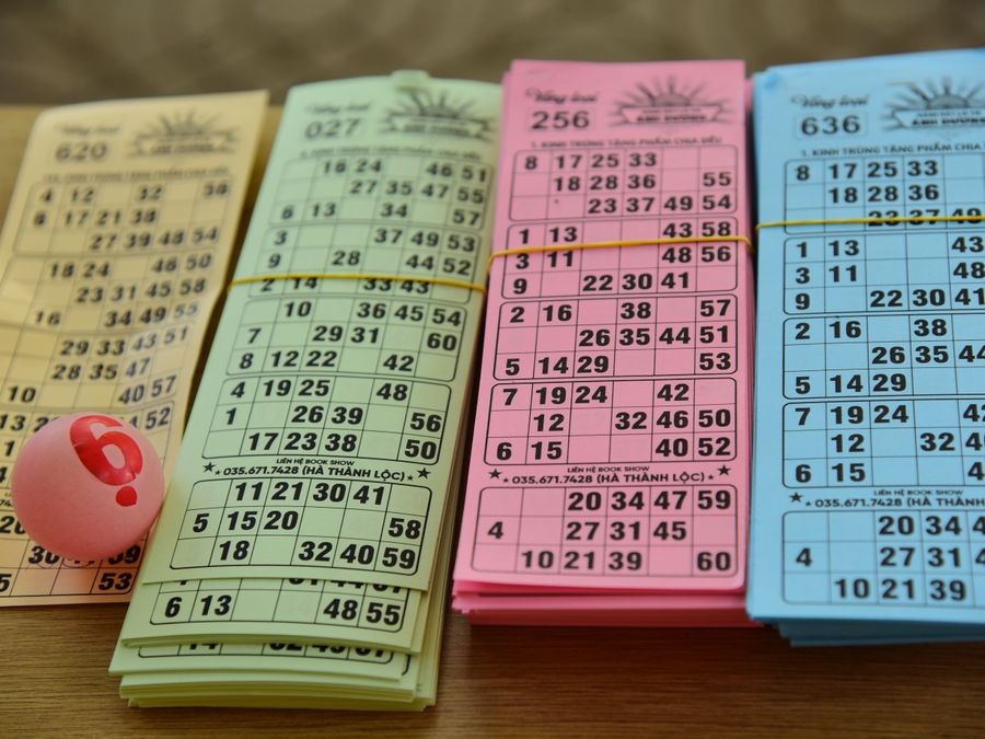 A set of colorful bingo cards and a numbered ball on a table, ready for a game night.