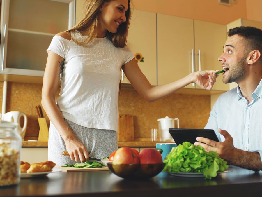 Happy couple preparing a healthy meal together in a modern kitchen.