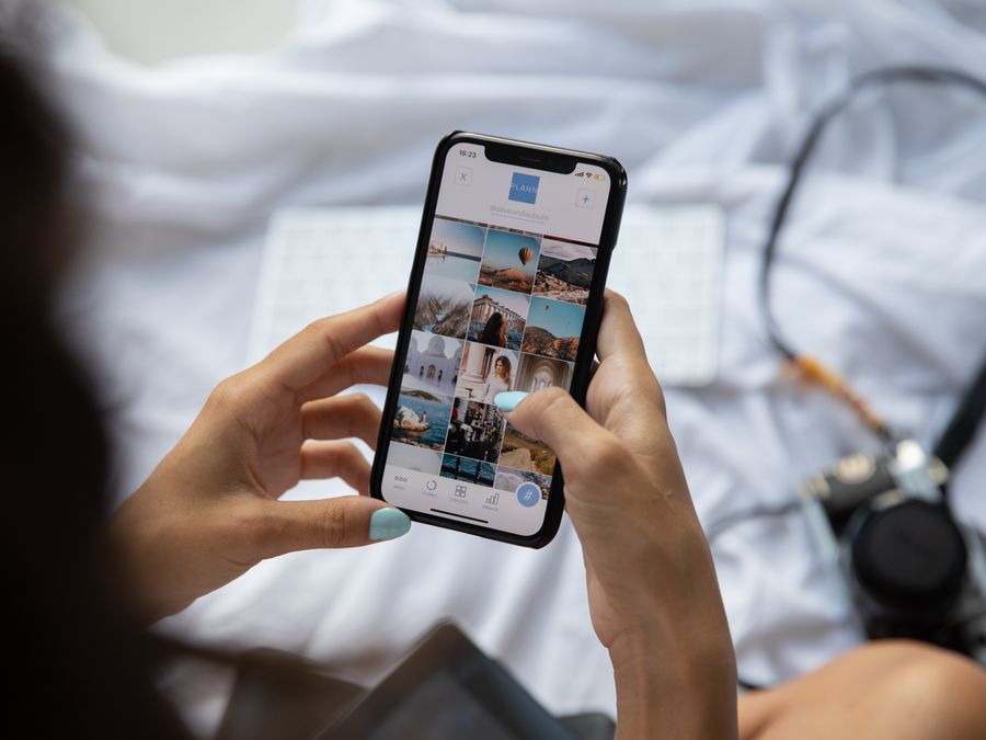 A person interacts with a smartphone displaying social media content in Bali, Indonesia.