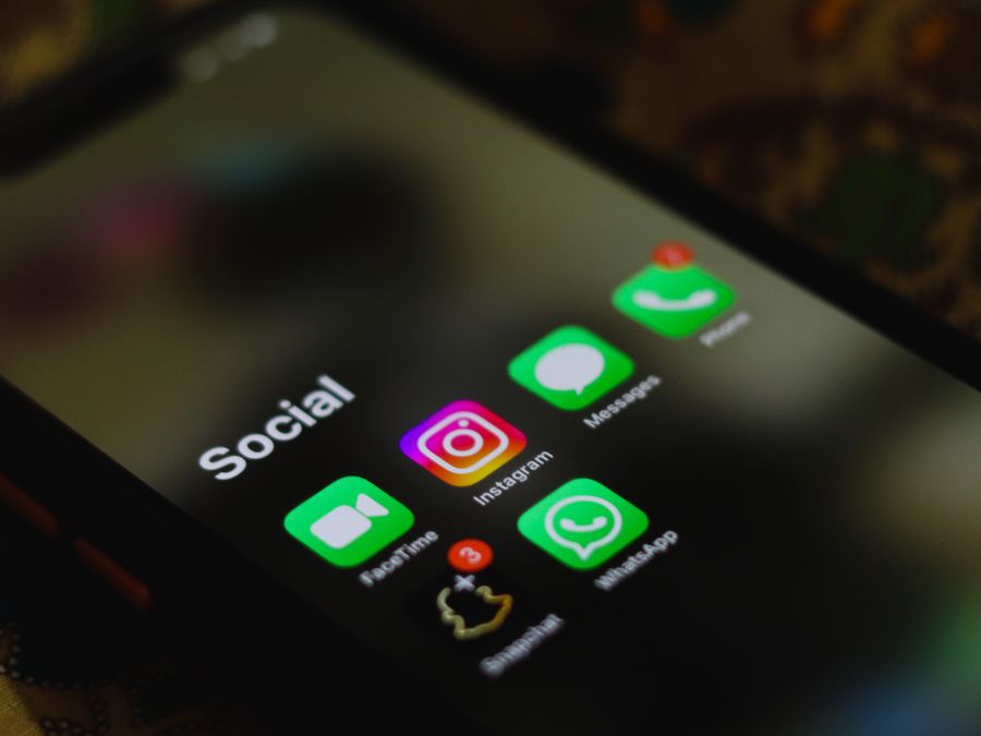 A close-up shot of smartphone displaying social media apps icons on screen.