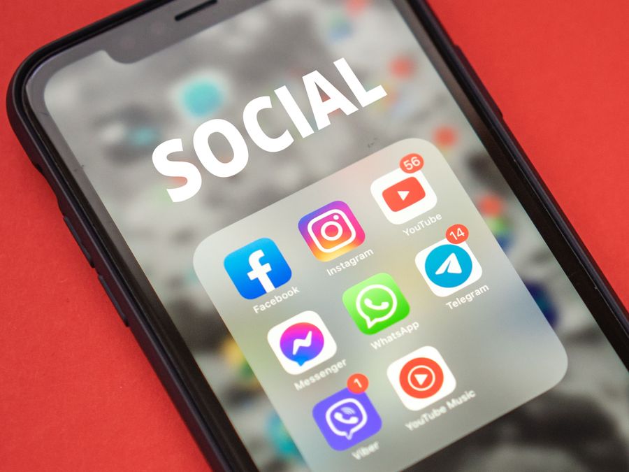 Close-up of a smartphone showing popular social media apps on screen.