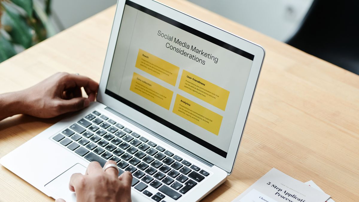 A person using a laptop to review social media marketing strategies at home.