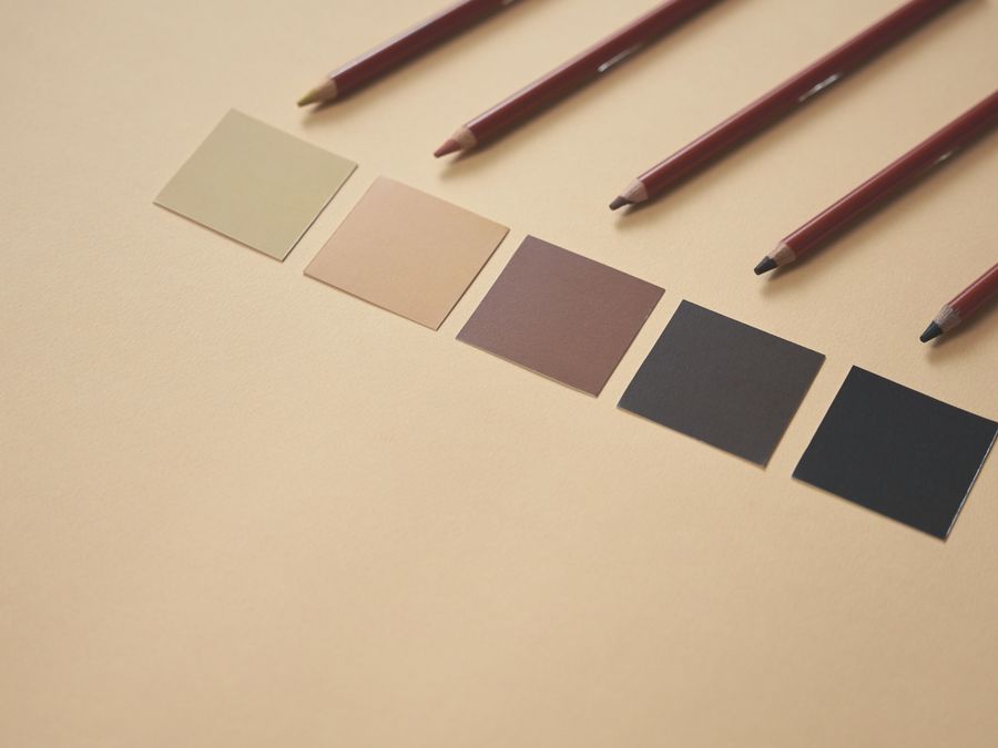 Creative arrangement of color swatches and pencils on a beige background, perfect for design concepts.