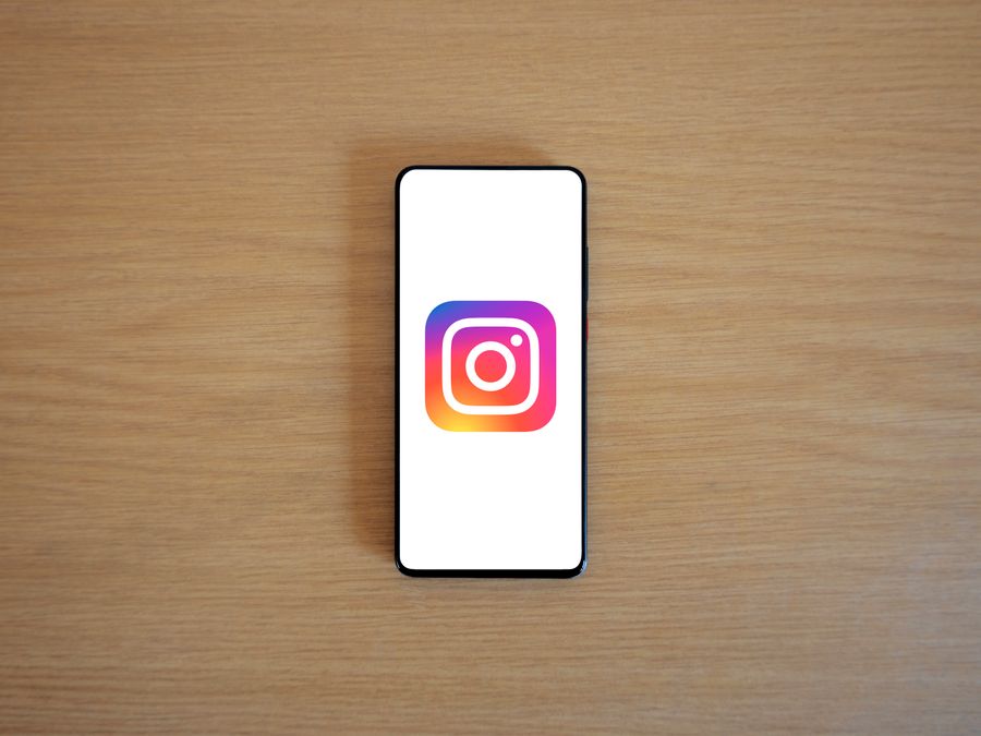 A smartphone with the Instagram logo on display, placed on a wooden surface. Perfect for technology and social media themes.
