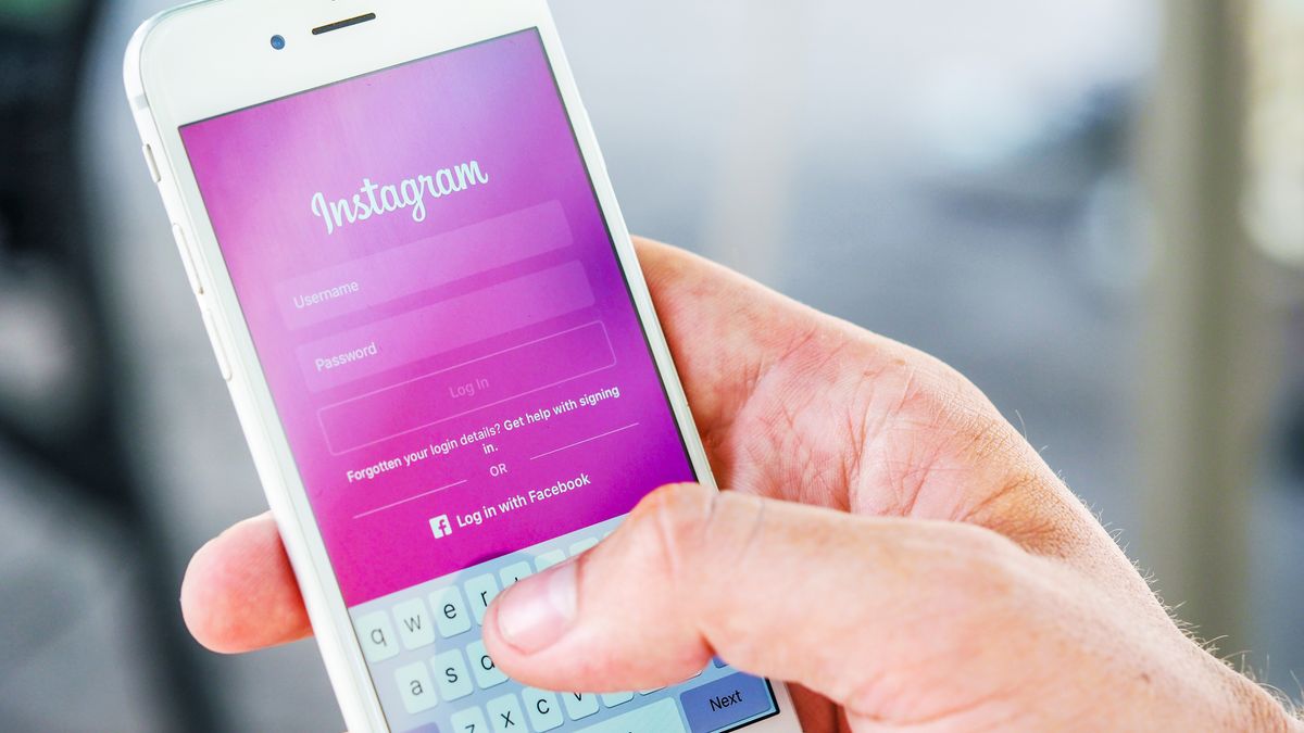 Close-up of a hand holding a smartphone displaying the Instagram login screen, highlighting mobile technology.