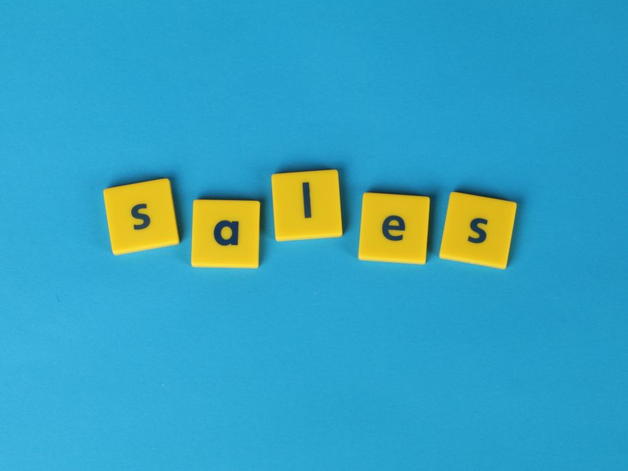 Yellow Scrabble tiles spelling 'sales' on a vibrant blue background. Perfect for marketing and business themes.