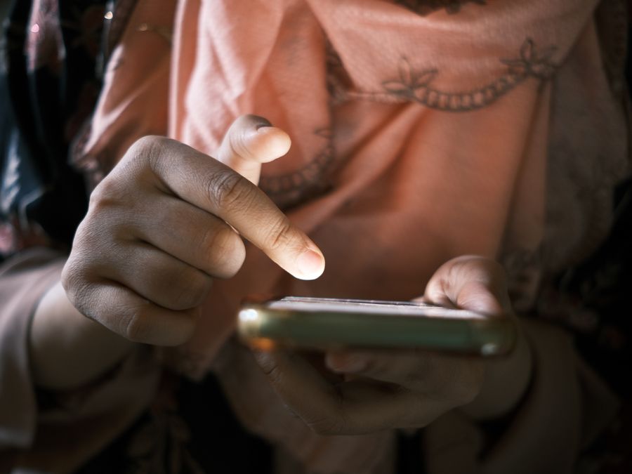 Close-up of hands using a smartphone indoors, highlighting touch technology.