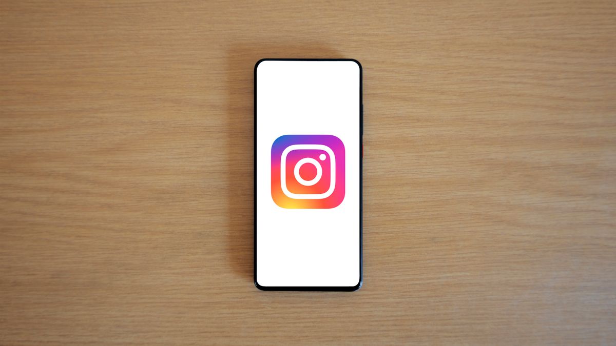 A smartphone with the Instagram logo on display, placed on a wooden surface. Perfect for technology and social media themes.