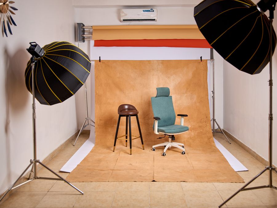 Stylish photo studio featuring lighting equipment and chairs for content creation.