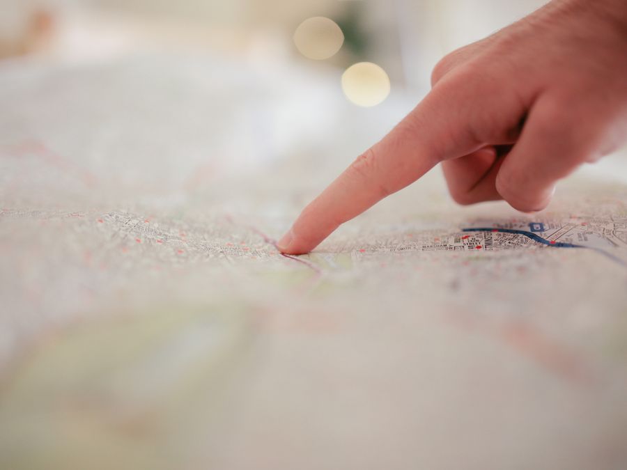 A hand pointing at a city map, highlighting direction and navigation planning.