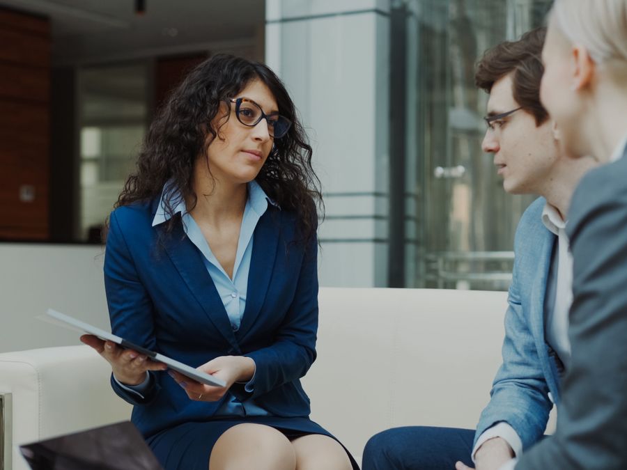 A professional meeting with a team discussing business strategies in a modern office setting.