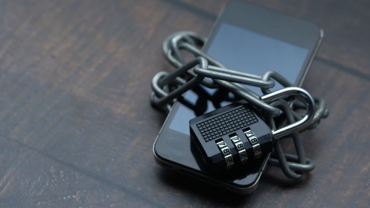 Close-up of a smartphone wrapped in a chain with a padlock, symbolizing strong security.