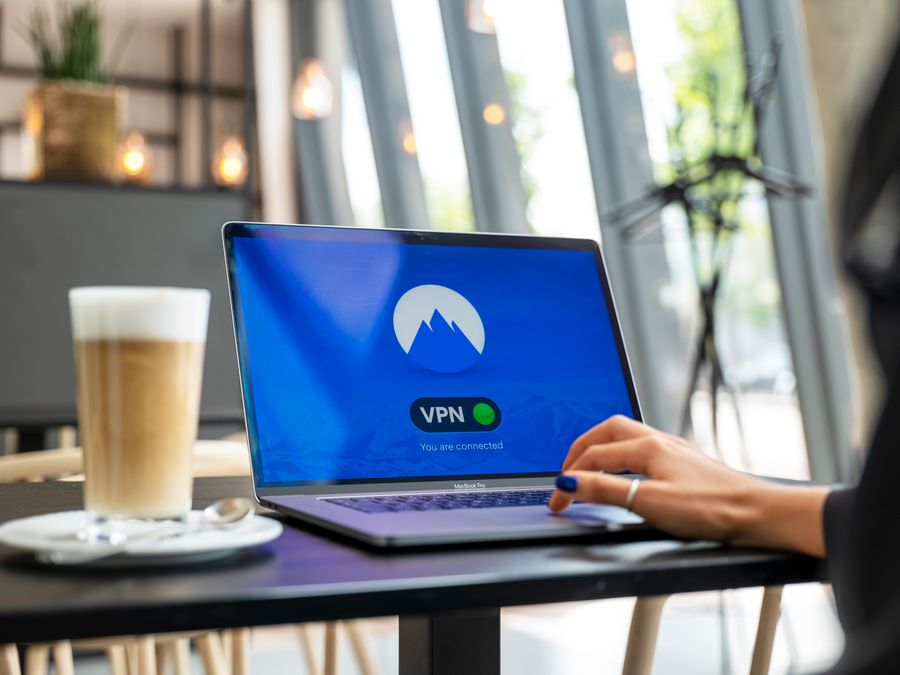 A person using a laptop with a VPN connection in a modern cafe setting, showcasing remote work and internet security.