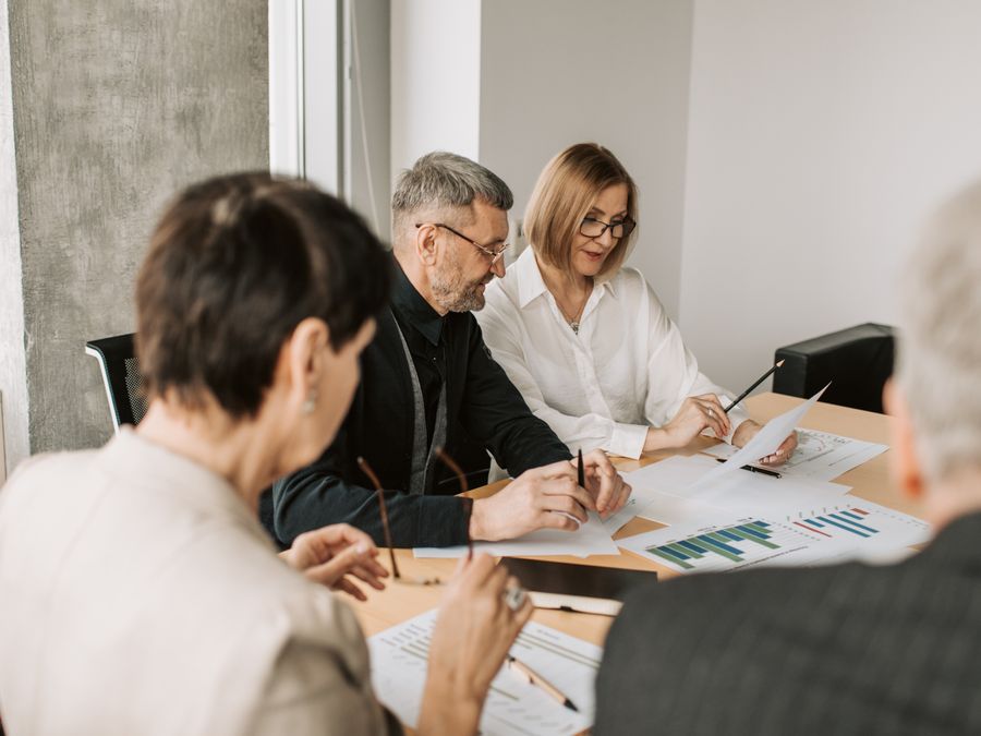 Team of professionals in office analyzing financial documents for business strategy.