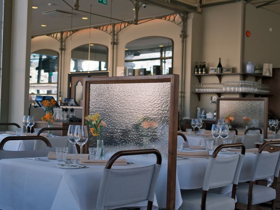 Elegant dining room with tables separated by decorative dividers for a cozy atmosphere.