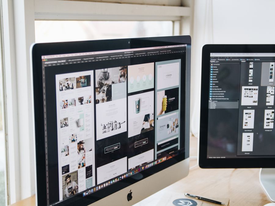 Modern office desk setup with dual monitors displaying design software, ideal for tech and business themes.