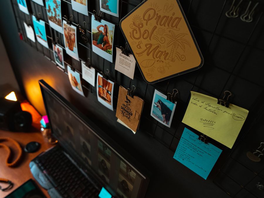 Modern workspace with photographs, notes, and a computer on a sleek desk.