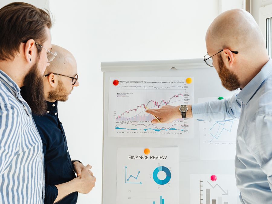 Business team reviewing financial charts during a strategy meeting indoors.