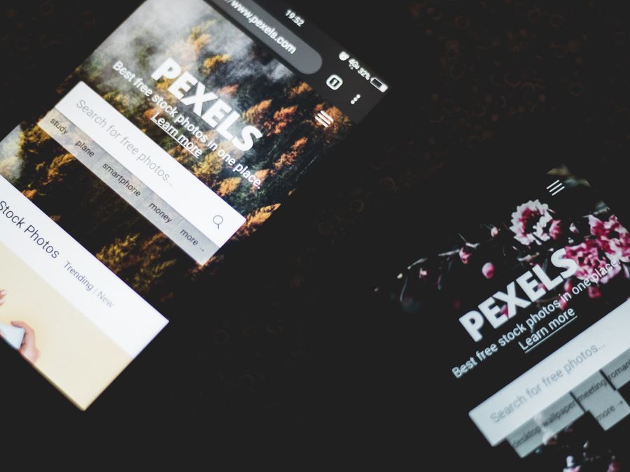 Close-up of smartphones displaying Pexels stock photo website, showcasing modern technology.
