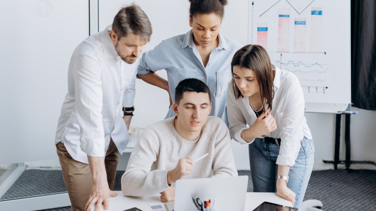 Group of professionals collaborating on a project with graphs in an office setting.