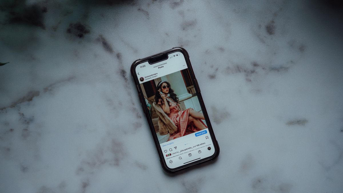 A smartphone showing an Instagram post against a marble background, showcasing modern social media use.