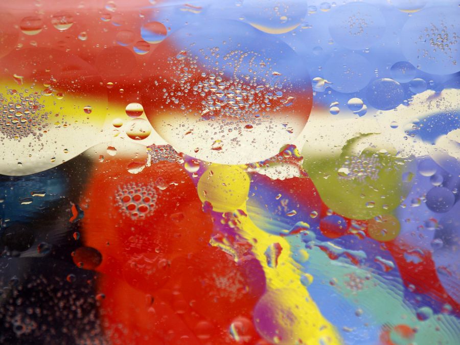 Vibrant abstract art featuring mesmerizing oil and water patterns with vivid colors and bubbles.