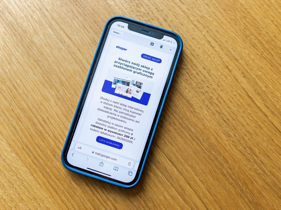 Close-up of a smartphone on a wooden table showing an online shopping webpage.