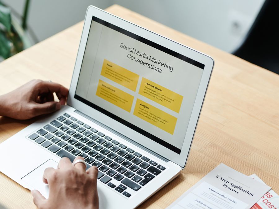 A person using a laptop to review social media marketing strategies at home.