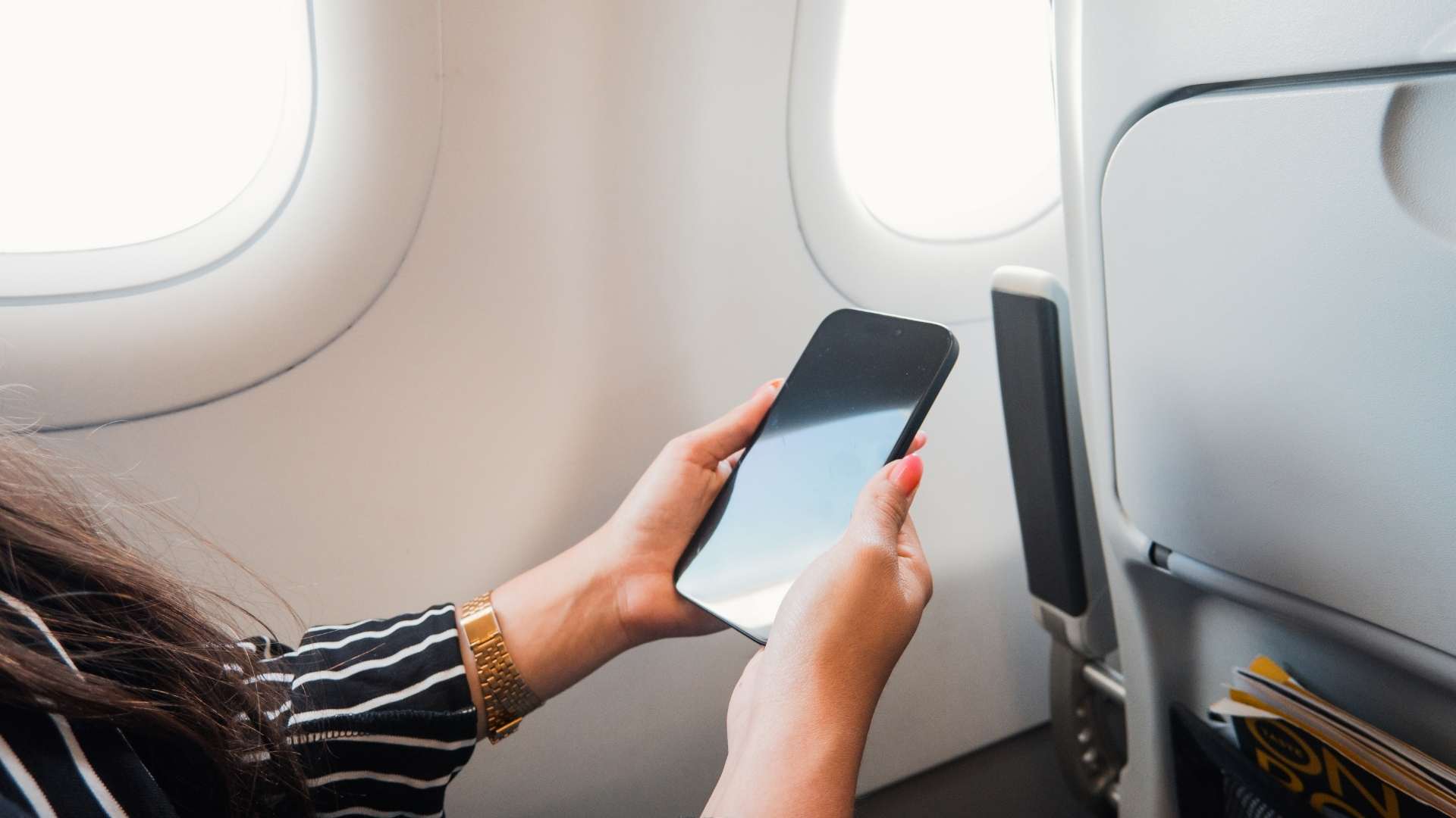 Traveler using a smartphone on a plane
