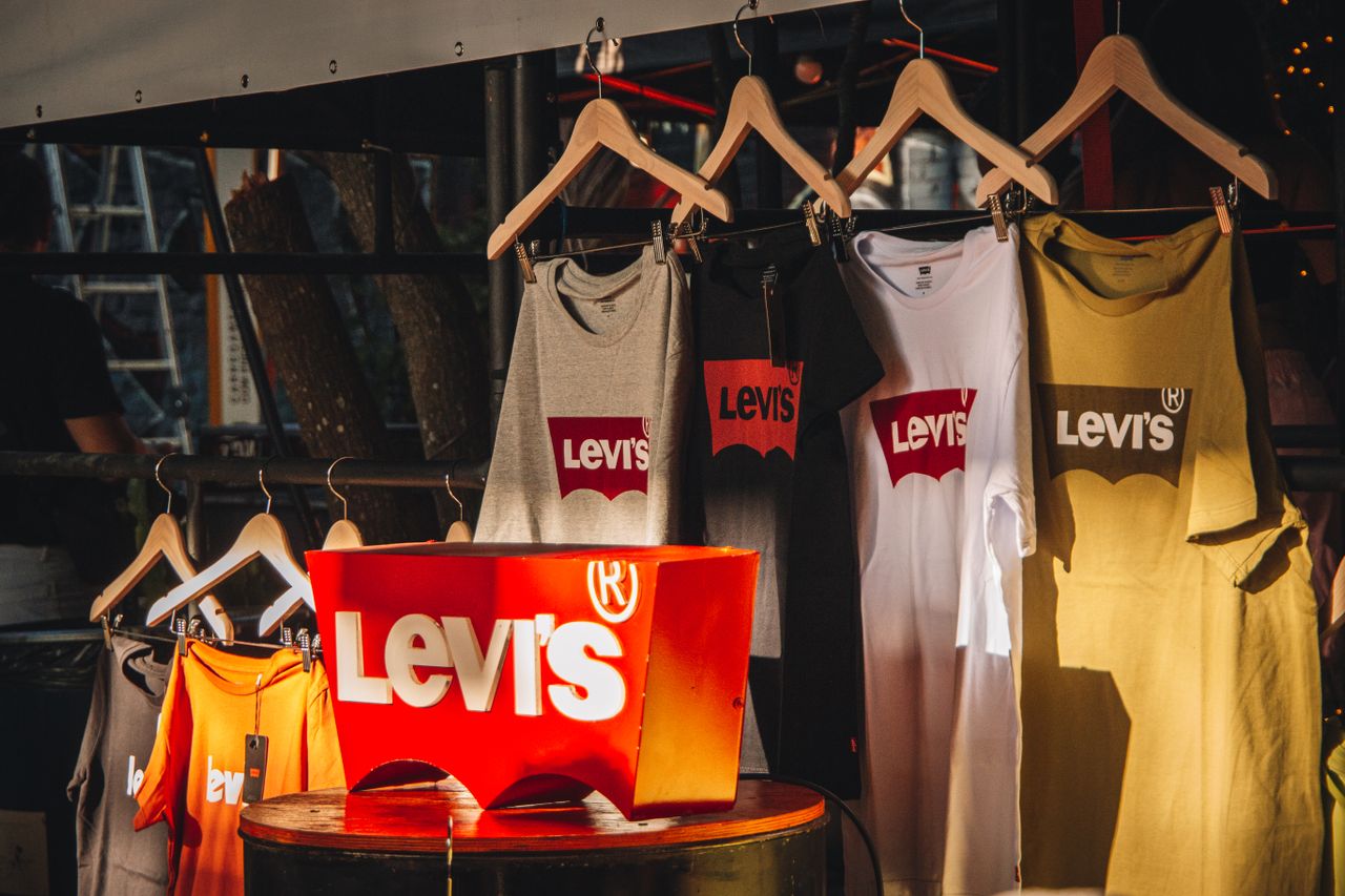 Branded T-shirts displayed with prominent company logos in a retail setting